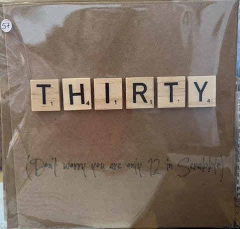 Card with 'THIRTY' spelled out using wooden tiles on a brown background.