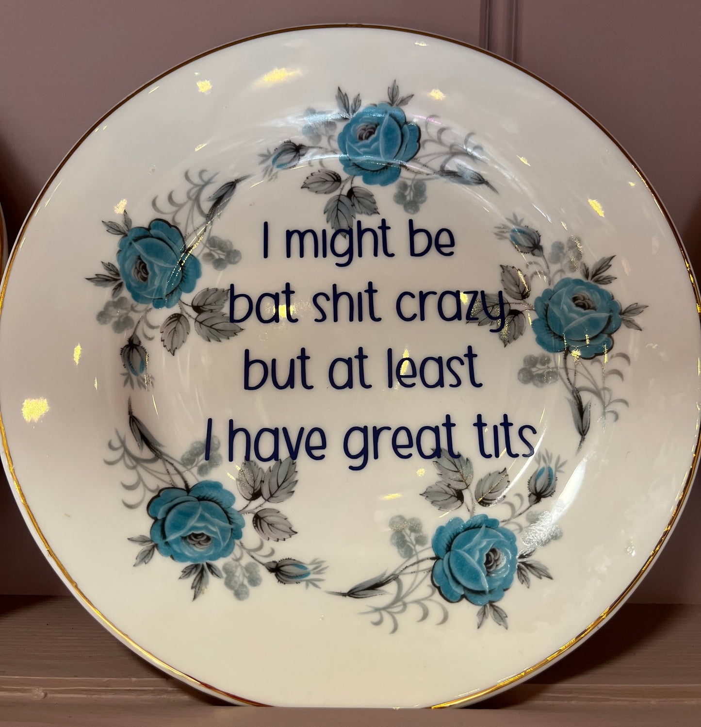 Decorative plate with floral design and text on a plain background