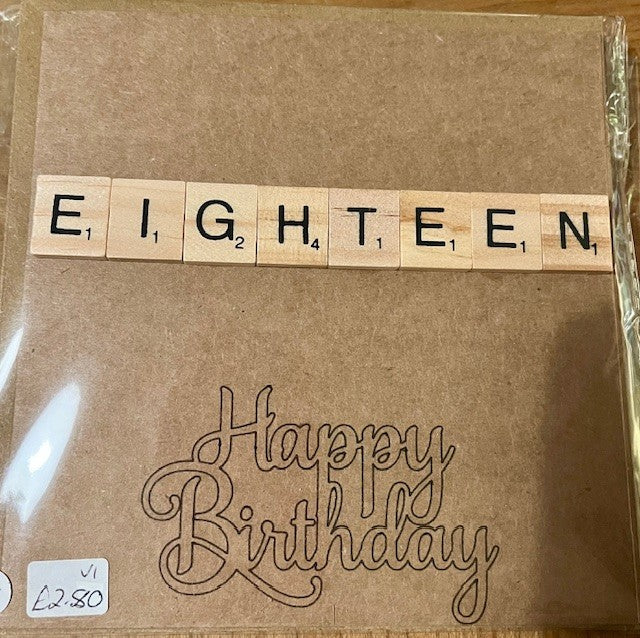 Brown greetings card with 'EIGHTEEN' spelled out using wooden tiles and 'Happy Birthday' text.