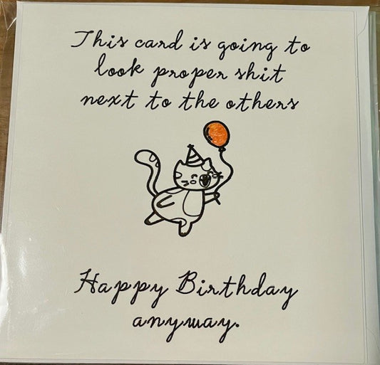 Birthday card with a cat illustration and humorous text on a plain background