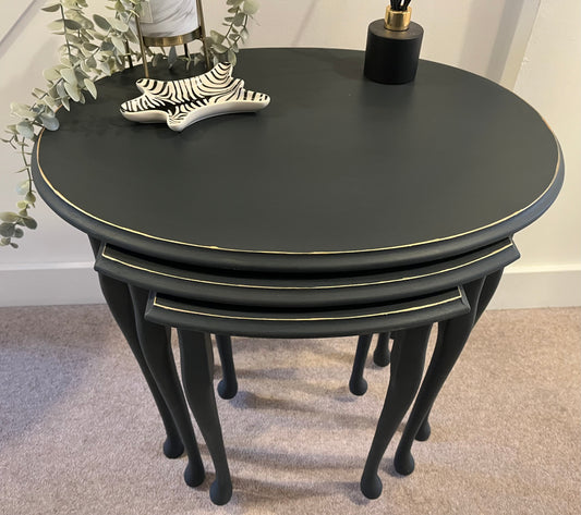 Set of three black nesting tables showing gold hand painted trim