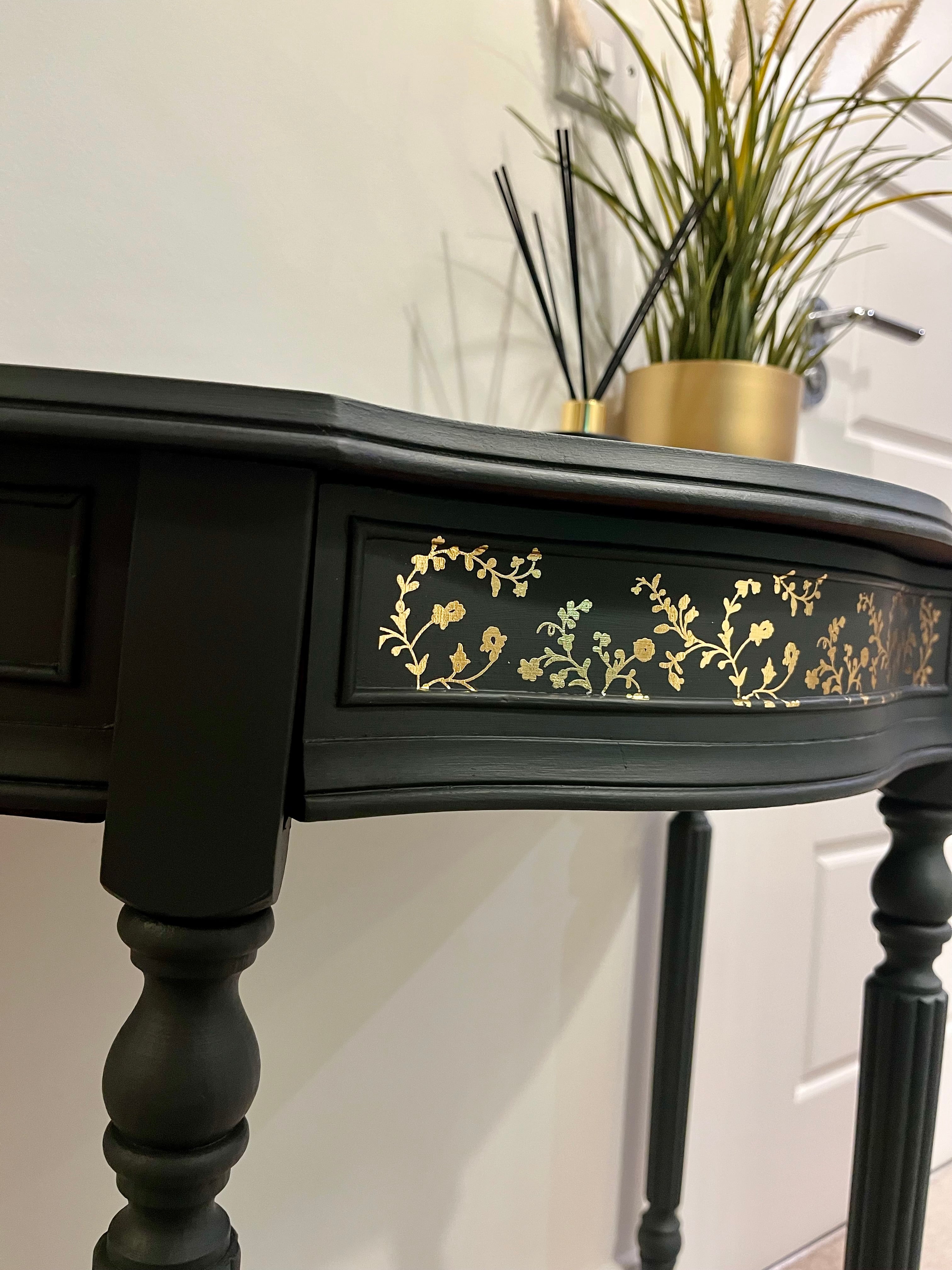 Black desk with gold floral patterns 