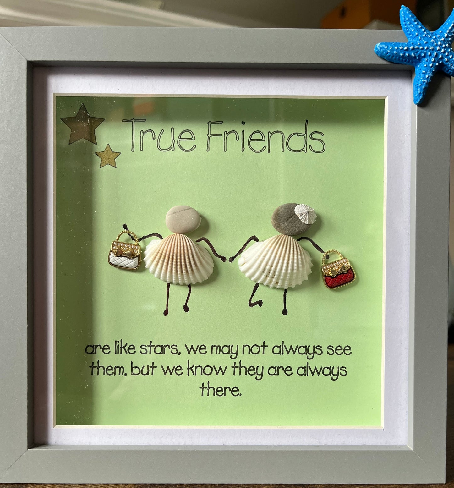 Framed artwork with seashells and text on a green background