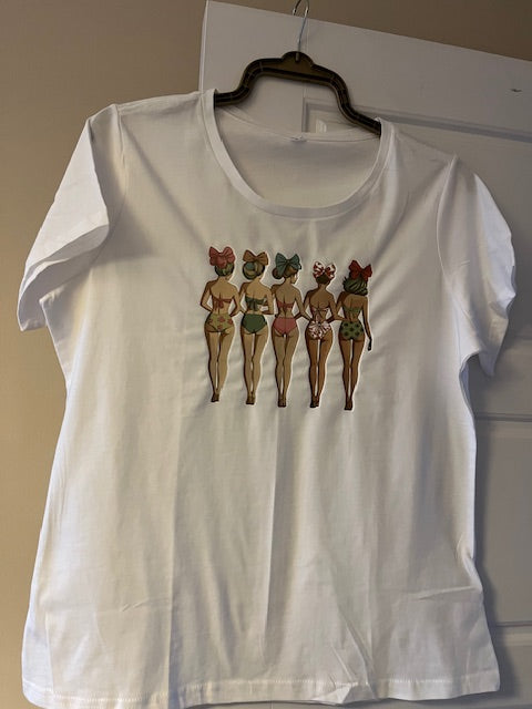 White t-shirt with vintage style ladies in bikinis arranged on it against a plain background