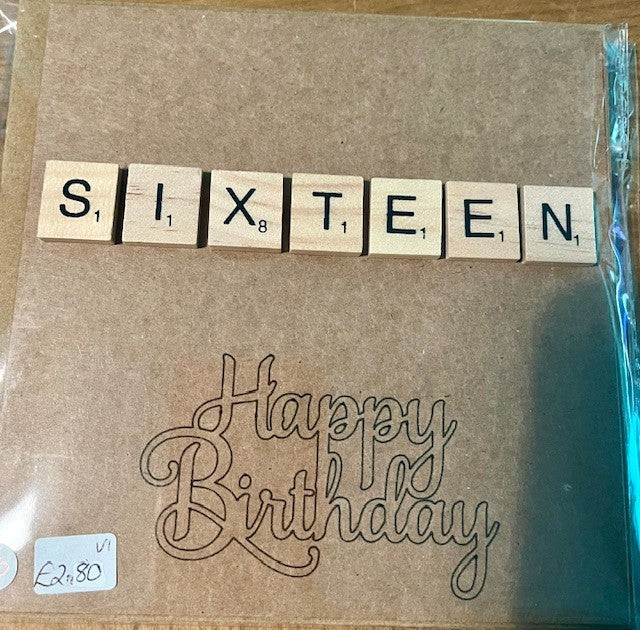 Brown greetings card with 'SIXTEEN' spelled out using wooden tiles and 'Happy Birthday' text.